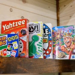 Board games on a wood shelf including Yahtzee, Uno and Skip-Bo