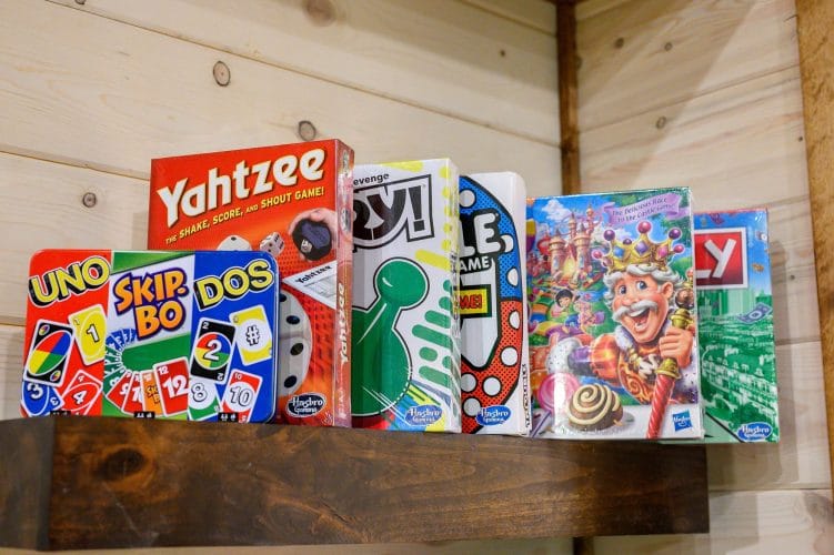 Board games on a wood shelf including Yahtzee, Uno and Skip-Bo