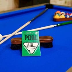 Close view of a blue pool table with cue sticks and balls