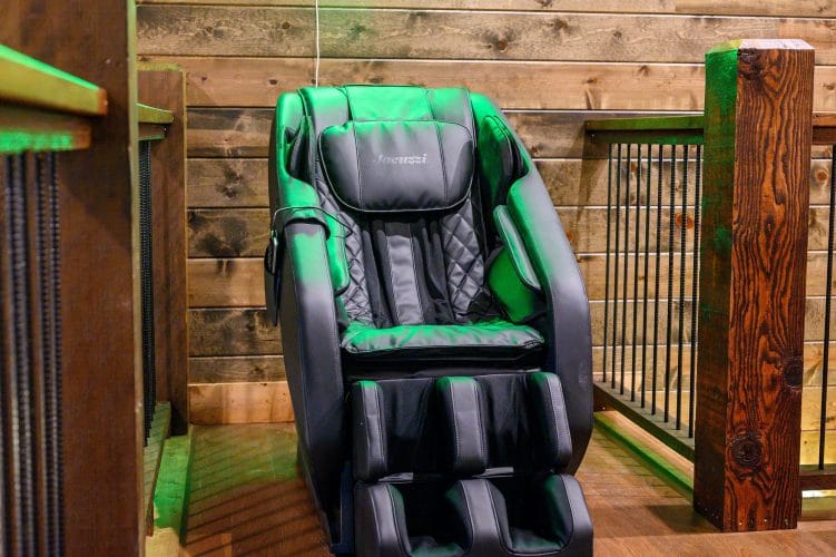 Black and green massage chair next to the loft railing