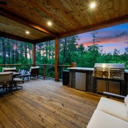 Covered deck with a dining table, built-in grill and sofa