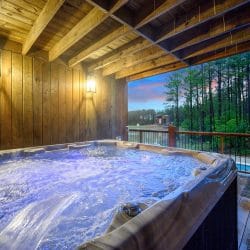 Hot tub on a covered lower deck with pines beyond