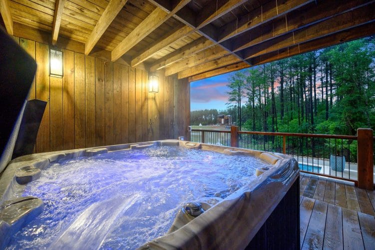 Hot tub on a covered lower deck with pines beyond