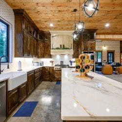 Marble-look island, farmhouse sink and dark wood cabinets