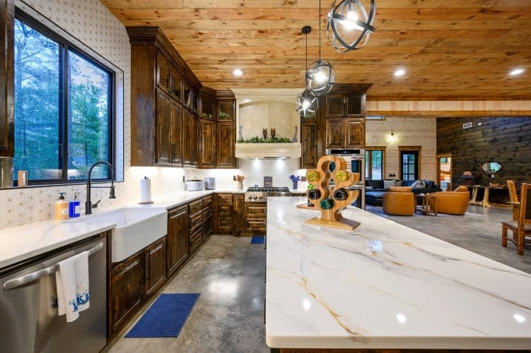 Marble-look island, farmhouse sink and dark wood cabinets