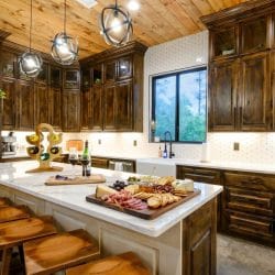 Island with bar stools and a charcuterie board, window over the sink behind