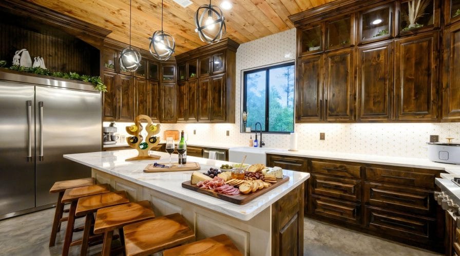 Island with bar stools and a charcuterie board, window over the sink behind