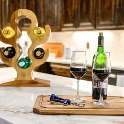 Wine bottle and glasses on the island with a wooden wine holder