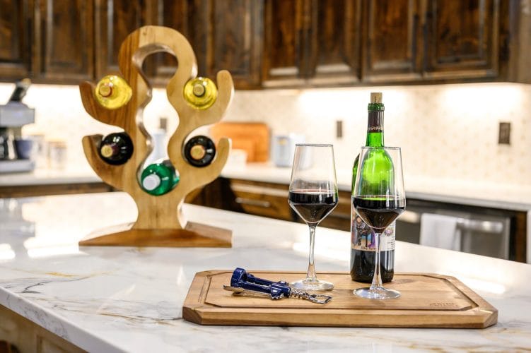Wine bottle and glasses on the island with a wooden wine holder