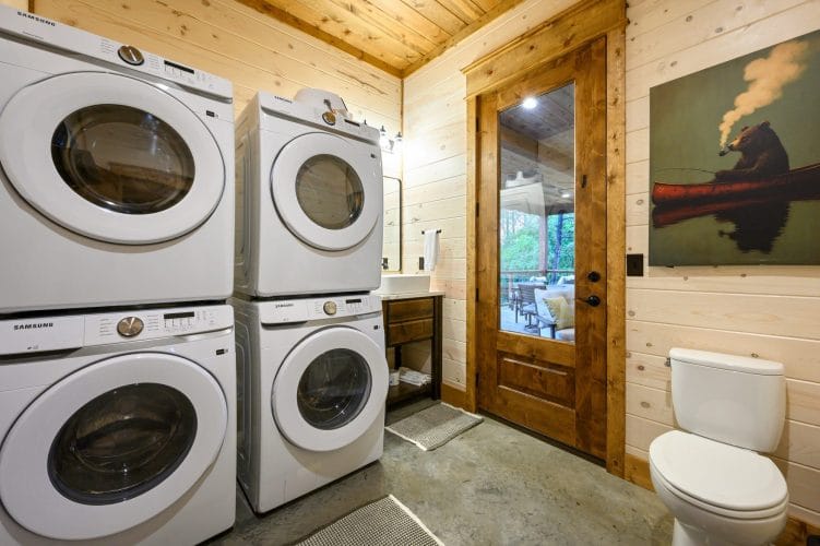 Two stacked washer and dryer sets next to the half bath