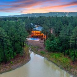 Aerial of the house and pool with a pond and creek in front