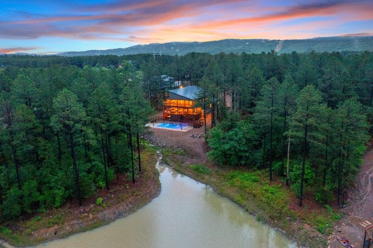 Aerial of the house and pool with a pond and creek in front