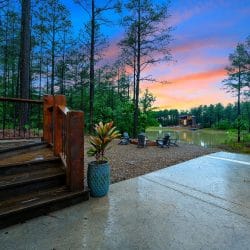 Deck steps to the patio and fire pit area by the water