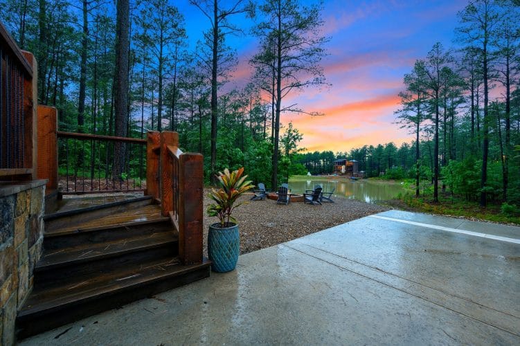 Deck steps to the patio and fire pit area by the water