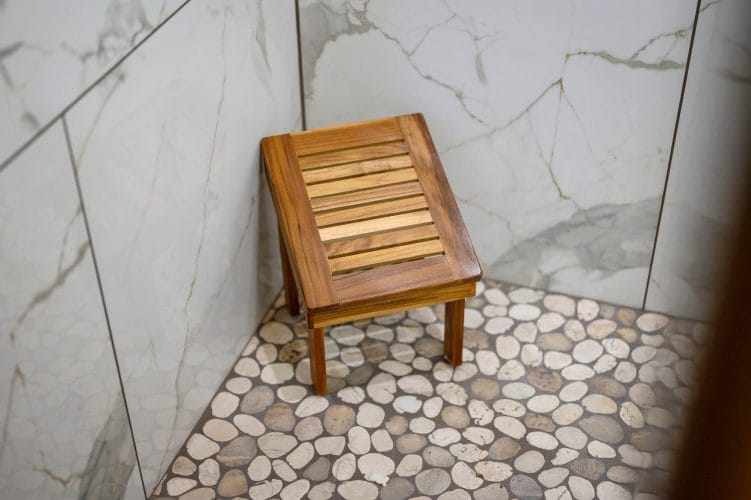 Wood shower bench inside a tiled shower
