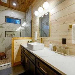 Vessel-sink vanity next to a tiled walk-in shower