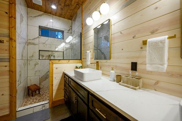 Vessel-sink vanity next to a tiled walk-in shower