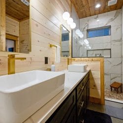 Vessel sink vanity with a marble-look tiled walk-in shower