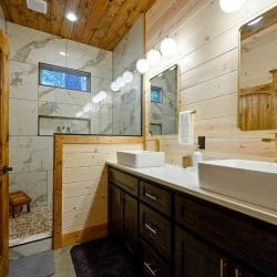 Double vanity beside a tiled walk-in shower