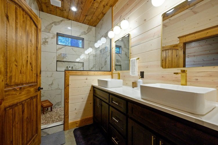 Double vanity beside a tiled walk-in shower