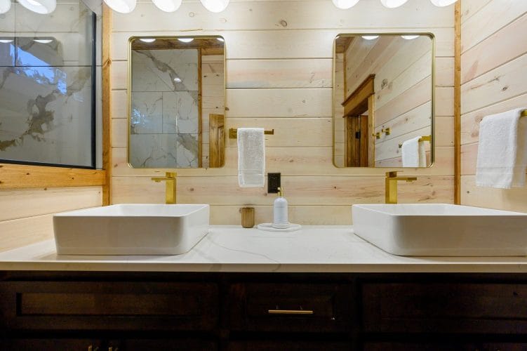 Two vessel sinks and mirrors over a dark wood vanity