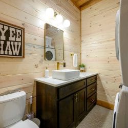 Half bath with a vessel sink, toilet and stacked washer and dryer