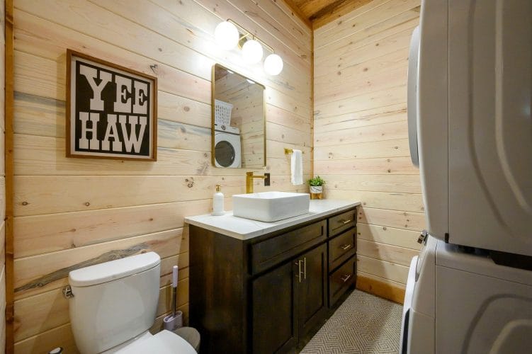 Half bath with a vessel sink, toilet and stacked washer and dryer