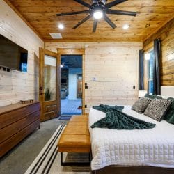 King bedroom with TV, dresser and a doorway to the patio