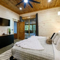 Same king bedroom with TV, dresser and glass door