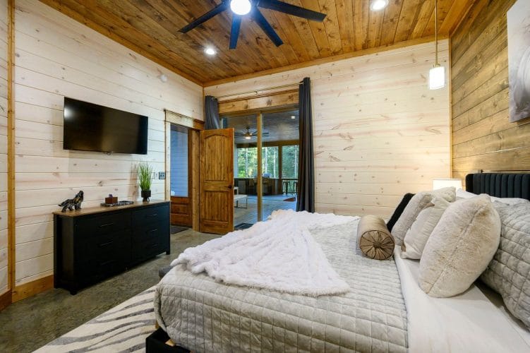 Same king bedroom with TV, dresser and glass door