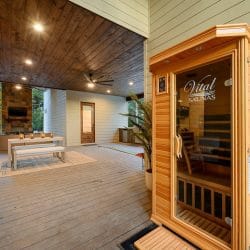 Covered patio with a wood infrared sauna cabin at right and a lounge area behind it