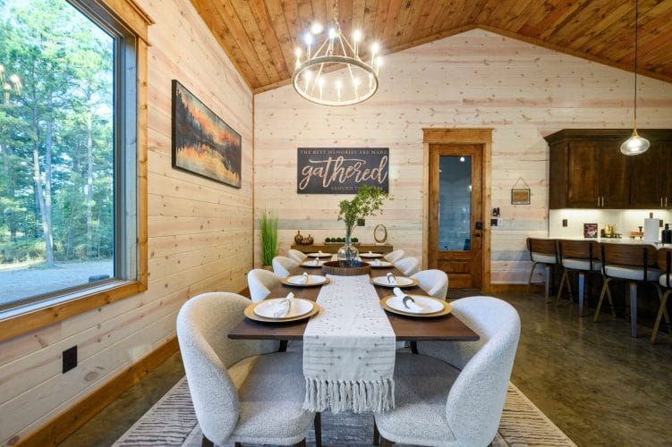 Dining table set for a meal with a framed 'gathered' sign behind it