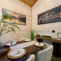 Dining table place settings with a 'gathered' sign on the wall