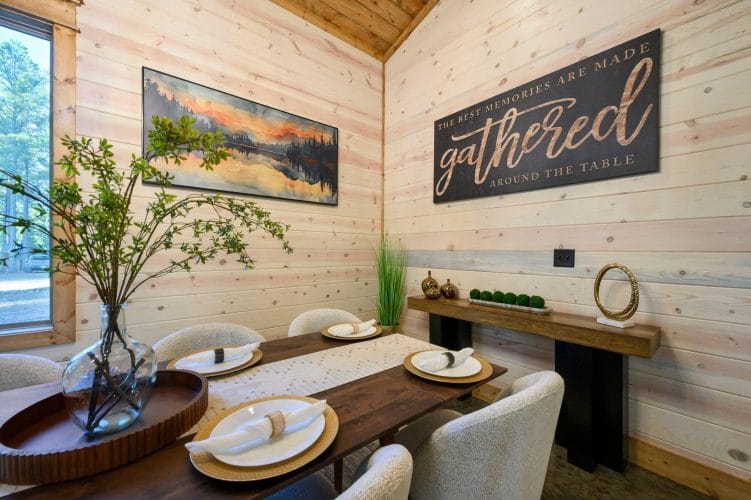 Dining table place settings with a 'gathered' sign on the wall
