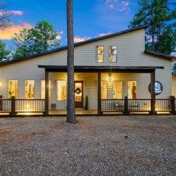 Front of the house with a covered porch lit at dusk