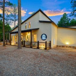 Front corner of the house with porch lights and pines