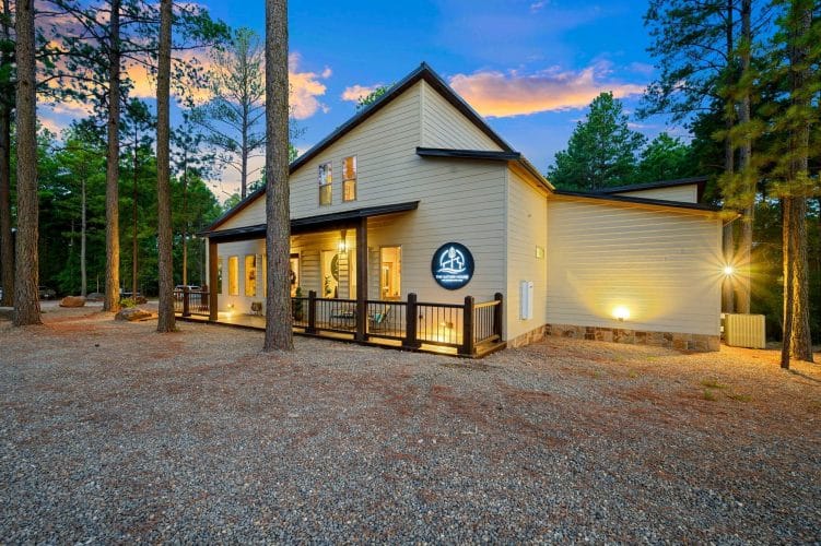 Front corner of the house with porch lights and pines