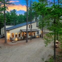 House seen through pines from the drive
