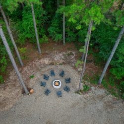 Aerial of the fire pit and ring of chairs in the pines