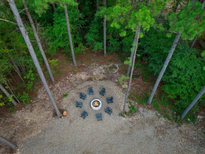 Aerial of the fire pit and ring of chairs in the pines