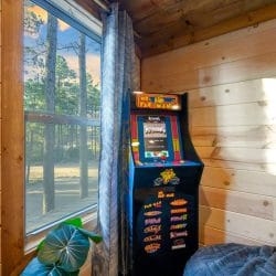 Upstairs arcade cabinet by a window with a bean bag chair