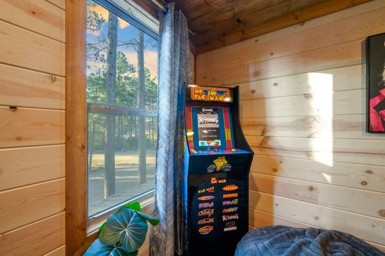 Upstairs arcade cabinet by a window with a bean bag chair