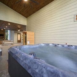 Hot tub on the covered patio with the sauna and seating behind it