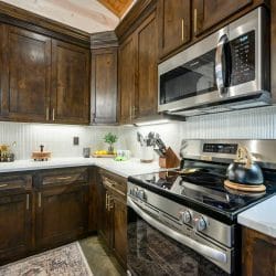Gas range and microwave with dark wood cabinets in the kitchen