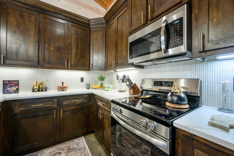 Gas range and microwave with dark wood cabinets in the kitchen