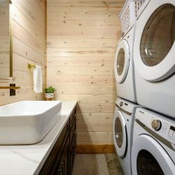 Vessel sink beside full-size washer and dryer in a bathroom