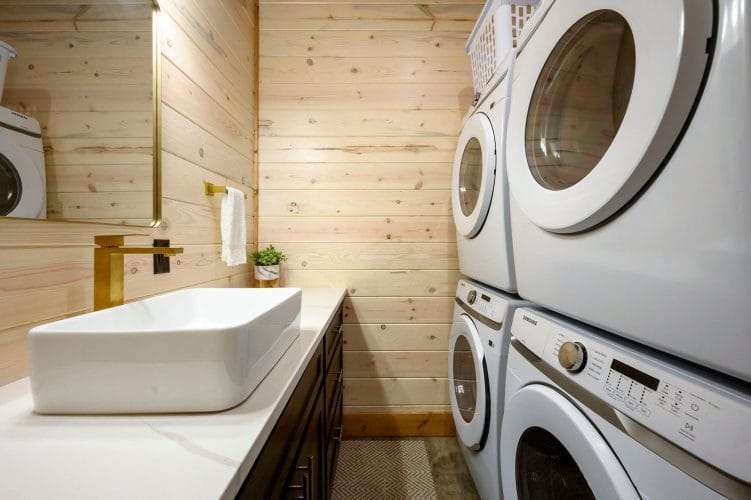 Vessel sink beside full-size washer and dryer in a bathroom