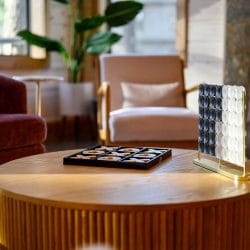 Round coffee table with board games, lounge chairs behind