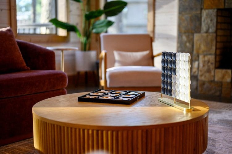 Round coffee table with board games, lounge chairs behind