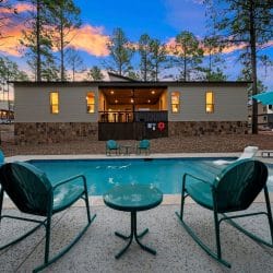 Two green rocking chairs beside the pool at dusk